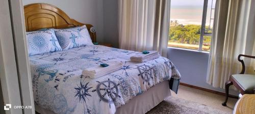 a bedroom with a bed with a view of the ocean at Tugela Mouth Sea View Guest House (Sleeps 8) in Tugela Mouth