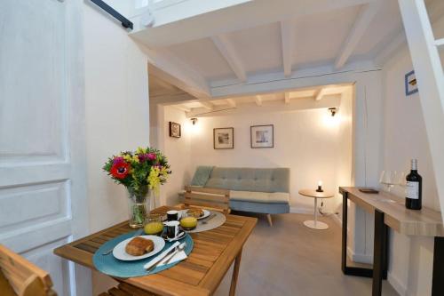 a living room with a table and a couch at LE PETIT BATEAU - NEW cosy/charming studio/mezzanine for 3 - AC/WIFI in Antibes