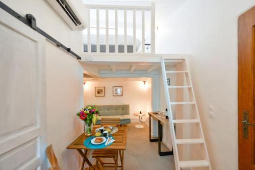 a small room with a loft bed and a table at LE PETIT BATEAU - NEW cosy/charming studio/mezzanine for 3 - AC/WIFI in Antibes