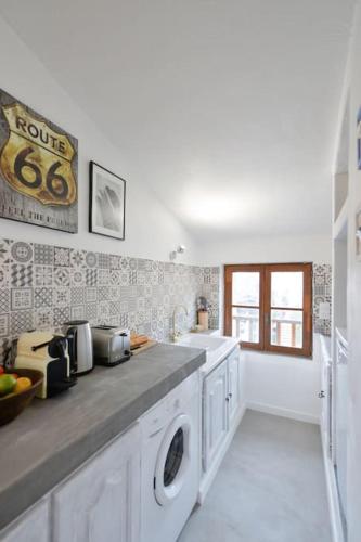 a kitchen with a sink and a washing machine at LE PETIT BATEAU - NEW cosy/charming studio/mezzanine for 3 - AC/WIFI in Antibes