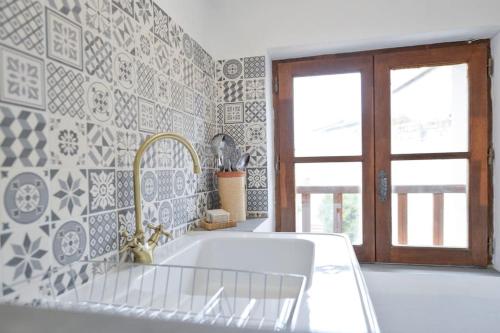 a white kitchen with a sink and a window at LE PETIT BATEAU - NEW cosy/charming studio/mezzanine for 3 - AC/WIFI in Antibes