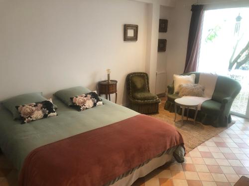 1 dormitorio con 1 cama, 1 silla y 1 ventana en La grande et petite porte de Samois, en Moret-sur-Loing