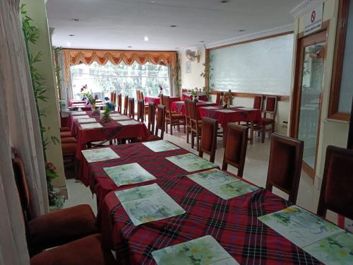 una sala da pranzo con tavoli, sedie e una lavagna bianca di Hotel Orchid a Guwahati