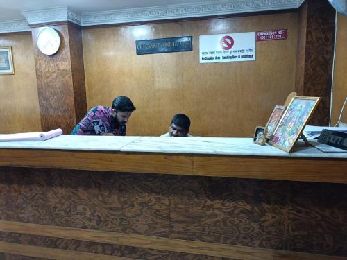 two people standing at the counter of a restaurant at Hotel Orchid in Guwahati