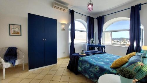 a bedroom with a blue bed and a window at Forio Family Home in Ischia
