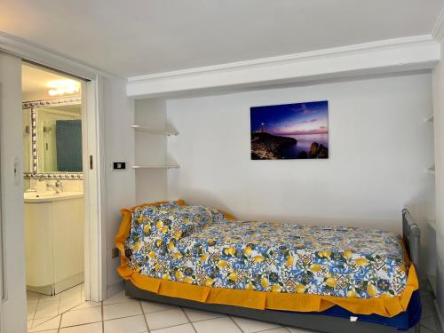 1 dormitorio con 1 cama con una foto en la pared en House via Orlandi for 5 people en Anacapri