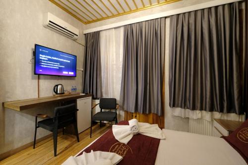 a hotel room with two beds and a desk and a television at CASA DE FRİDA'S BEŞİKTAŞ in Istanbul