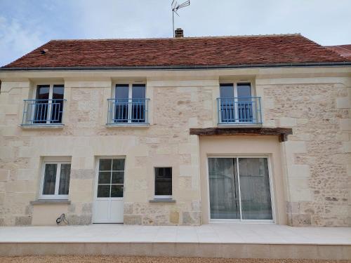 a stone house with blue windows and a roof at Cosy Casa in Saint-Romain-sur-Cher