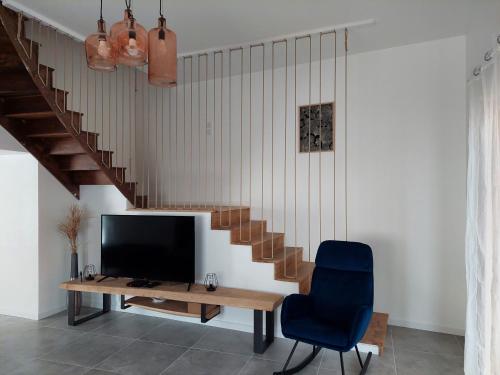 Il comprend un salon doté d'une télévision, d'un bureau et d'un escalier. dans l'établissement Cosy Casa, à Saint-Romain-sur-Cher