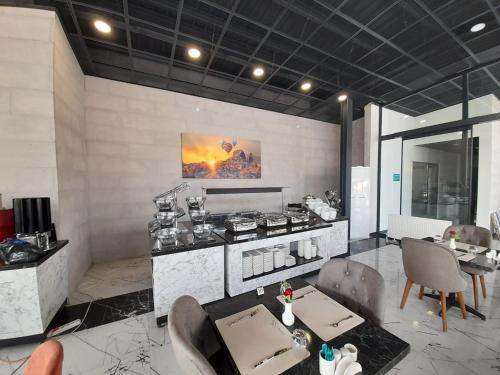 a kitchen with a stove and a table with chairs at VE HOTELS KAPADOKYA in Nevşehir