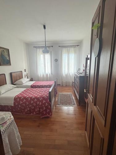 a bedroom with two beds and a dresser and a door at B&B Relax in Miane