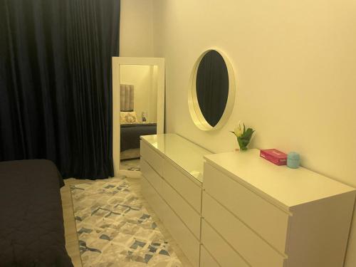 ein Schlafzimmer mit einer Kommode mit einem Spiegel und einer Kommode in der Unterkunft Abdoun apartment in Amman