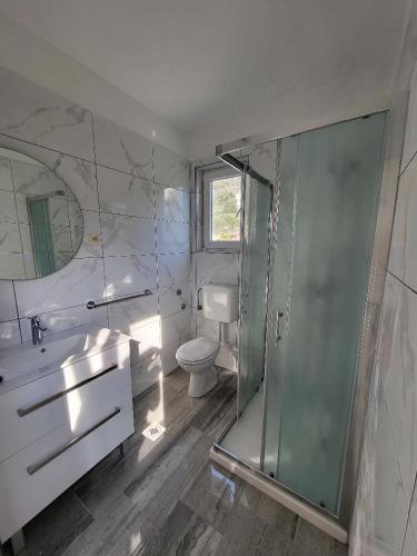 a bathroom with a shower and a sink and a toilet at Apartmani Mira in Rab