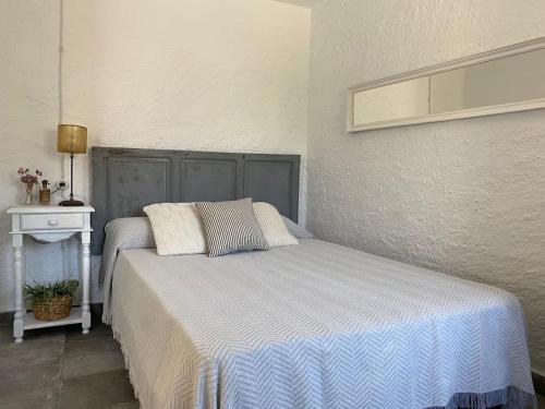 a bedroom with a bed with a blue and white blanket at La melillera in Las Hortichuelas Bajas