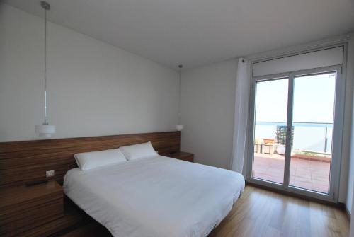 1 dormitorio con cama blanca y ventana grande en Picasso Street, en Vilassar de Mar