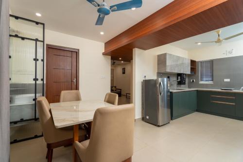 een keuken en eetkamer met een tafel en een koelkast bij Lumiere Premium Apartments in Trivandrum