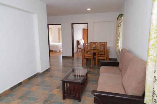 a living room with a couch and a table at Seven Endue Delight with Mountain view on the Hill Top in Ooty