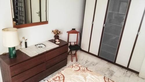 una camera da letto con cassettiera, specchio e tavolo di Grattacielo Apartment a Rapallo