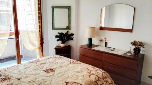 a bedroom with a bed and a dresser and a mirror at Grattacielo Apartment in Rapallo