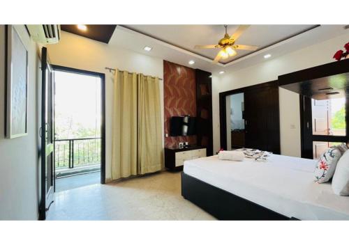 a bedroom with a large bed and a balcony at BluO Studio - M Block Mkt Greater Kailash in New Delhi