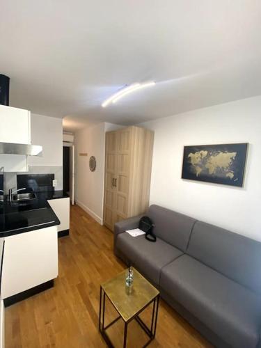 un salon avec un canapé et une cuisine dans l'établissement Appartement proche mer, à Nice
