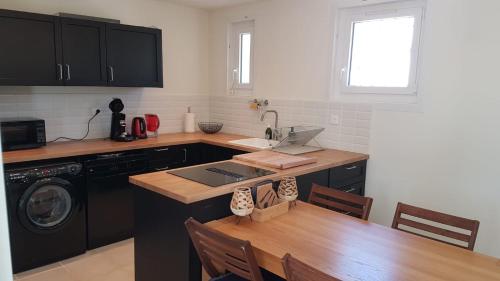 a kitchen with a table and a sink and a stove at Villa KPS in Pujaut
