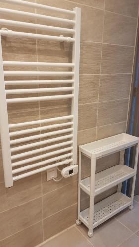 une étagère blanche dans une salle de bains à côté d'un mur dans l'établissement Villa KPS, à Pujaut