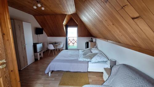 a bedroom with a bed with a wooden ceiling at O.W. MEGA nad jeziorem in Żywiec