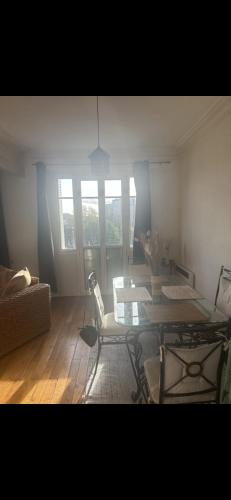 un salon avec une table et une chaise dans l'établissement Appartement proche de Paris, à Deuil-la-Barre