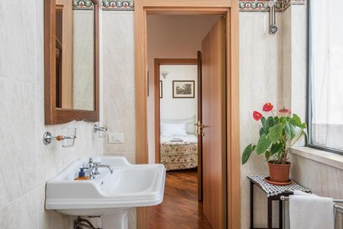 een badkamer met een wastafel en een spiegel bij Secret Garden Siena in Siena