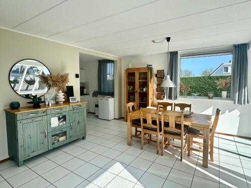 a kitchen and dining room with a table and chairs at Bohemien Resort 46 in Sint Maartensvlotbrug