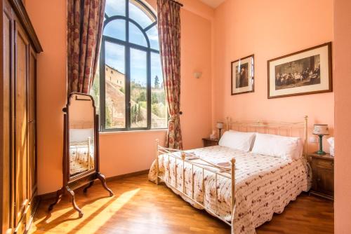 Un dormitorio con una cama y una ventana grande. en Secret Garden Siena, en Siena
