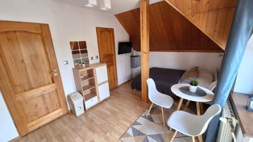 a small room with a table and chairs and a staircase at O.W. MEGA nad jeziorem in Żywiec