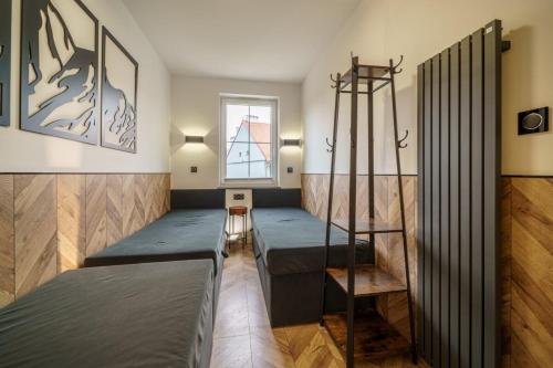 Habitación con 2 camas y escalera. en Apartament Agat H2 z prywatną SAUNĄ - Mountain Aparts en Świeradów-Zdrój