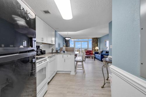 a kitchen with white cabinets and a living room at Atlantica Resort Condo Oceanfront Close to the beach in Myrtle Beach