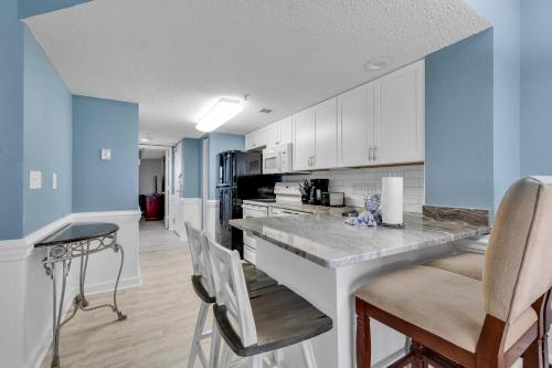 a kitchen with blue walls and a counter with chairs at Atlantica Resort Condo Oceanfront Close to the beach in Myrtle Beach