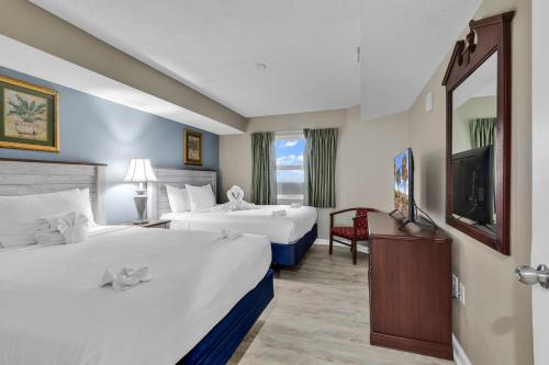 a hotel room with two beds and a television at Atlantica Resort Condo Oceanfront Close to the beach in Myrtle Beach