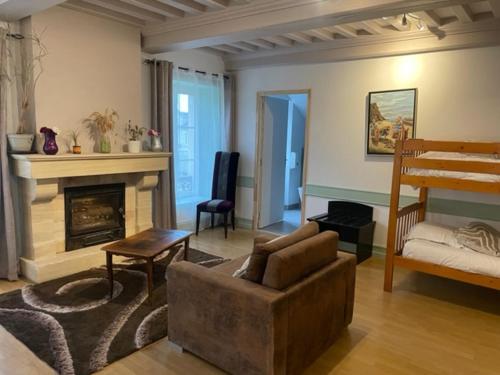 a living room with a couch and a fireplace at Hôtel Le Bayeux in Bayeux