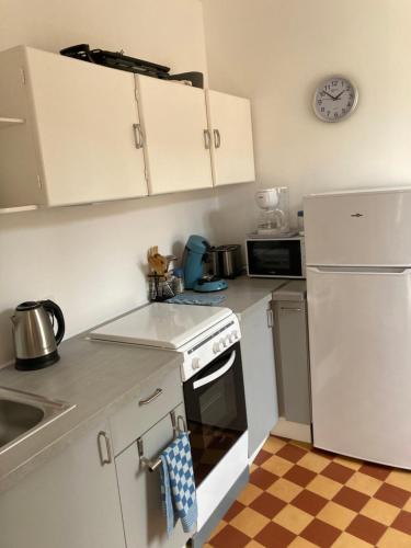 una cucina con armadietti bianchi, piano cottura e frigorifero di Principale@Brandon a Brandon