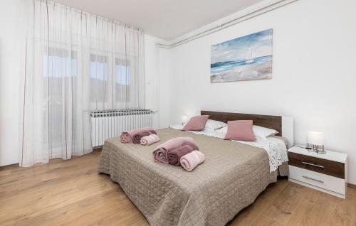 a bedroom with two beds with pink pillows on them at Apartman Nora in Mučići