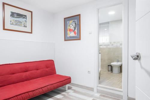 un sofá rojo en una habitación con baño en Oviedo Rural en Oviedo