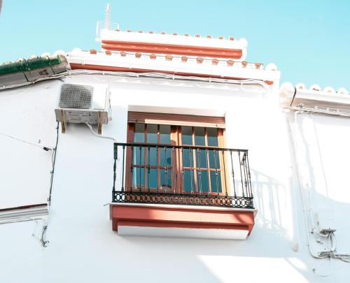 un balcón en el lateral de un edificio blanco en Casita Molino de Erillas, en Álora