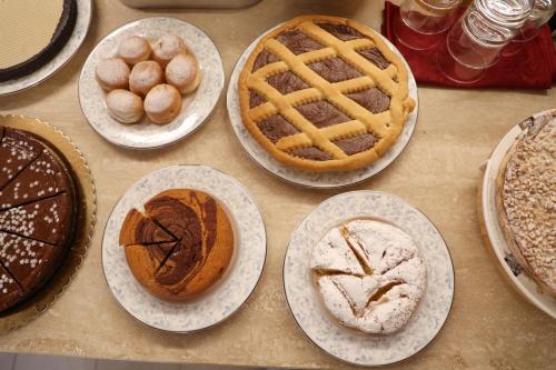 a table topped with plates of cakes and pastries at Antica Colombaia in San Marino