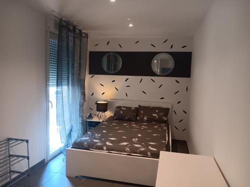 - une chambre avec un lit et un mur orné d'oiseaux dans l'établissement MIRANEO, à Miramas