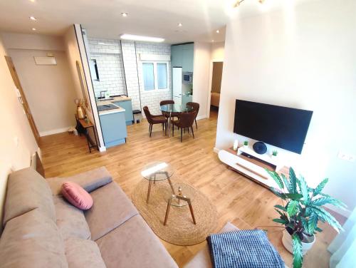 sala de estar con sofá y TV de pantalla plana en Sweet Aviles Apartamento, en Avilés