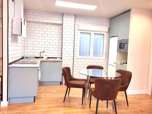 Sweet Aviles Apartamento في أفيليس: مطبخ مع طاولة وكراسي في غرفة