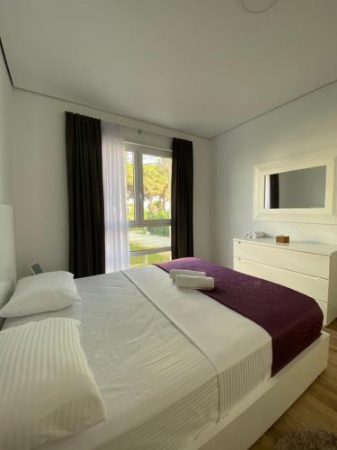 Un dormitorio con una cama grande y una ventana en Vila Margo, San Pietro Resort, Lalez, en Durrës