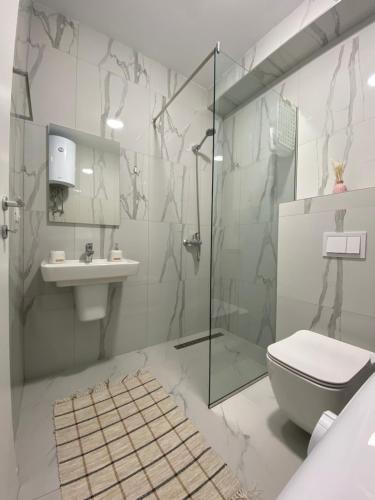 y baño con ducha, aseo y lavamanos. en Vila Margo, San Pietro Resort, Lalez, en Durrës