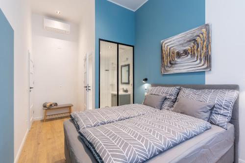 a bedroom with a bed and a blue wall at Izabella66 apartment in Budapest