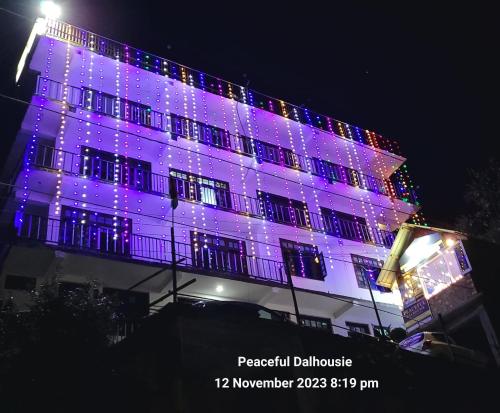 a building lit up in purple with christmas lights at Peaceful Retreat Home Stay in Dalhousie